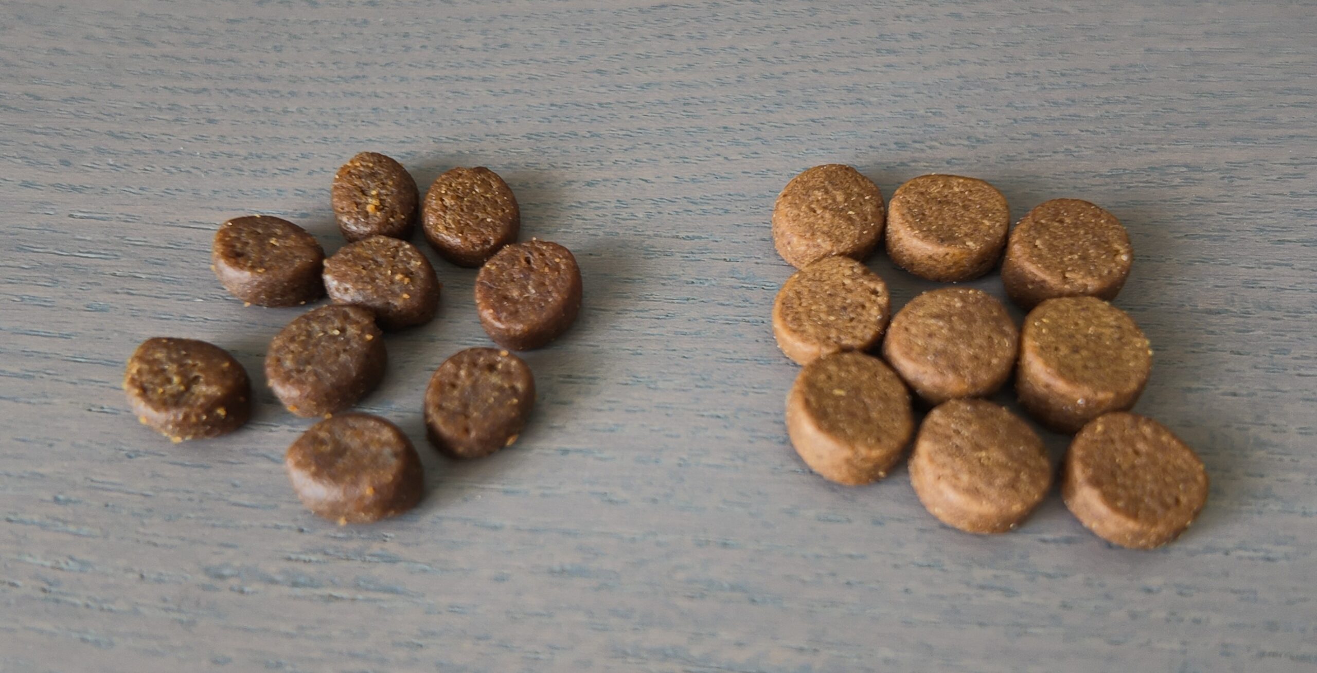 Photo montrant des croquettes Amikinos d'une même composition mais pas de la même production. Les croquettes des 2 productions ne sont pas de la même couleur ni de la même taille.